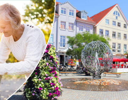 Ältere Frau stützt eine alte Dame. Stadtbild mit Springbrunnen.